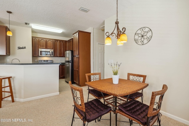 7157 Deerfoot Point Cir Unit 10-2, Jacksonville, FL 32256 - dining space with baseboards, visible vents, a chandelier, and a textured ceiling