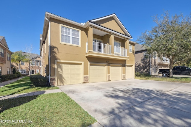 view of front of house featuring a garage, driveway, a front yard, and stucco siding