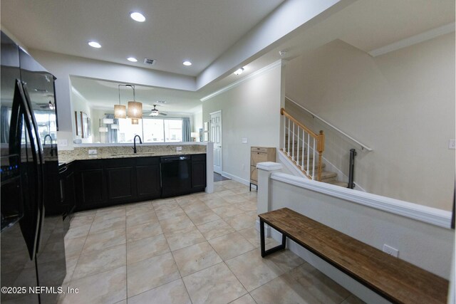 kitchen with light stone counters, visible vents, a sink, dark cabinetry, and black appliances