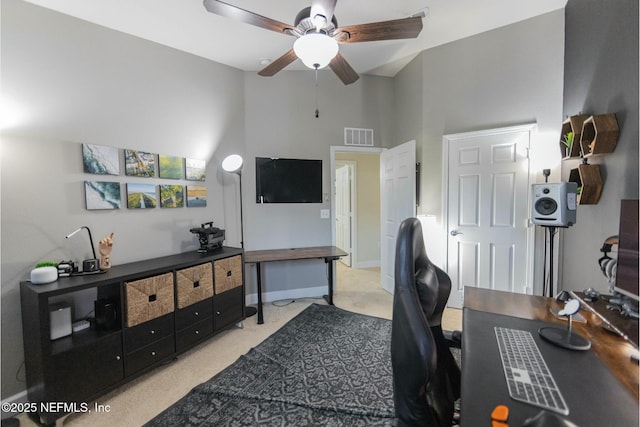 office with baseboards, a towering ceiling, visible vents, and a ceiling fan