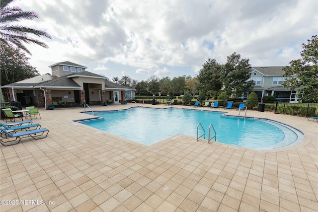 community pool featuring a patio area and fence