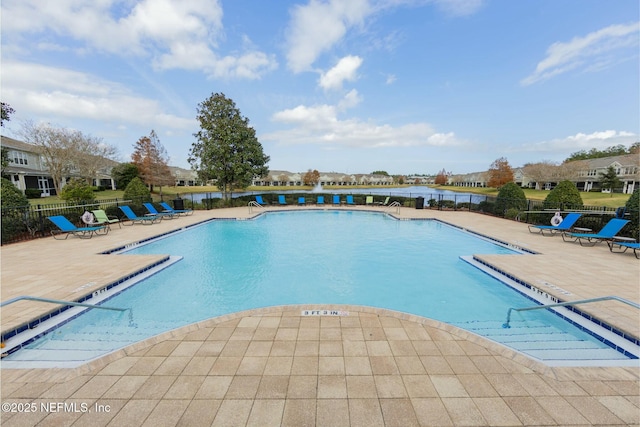 pool with a water view, a patio, and fence