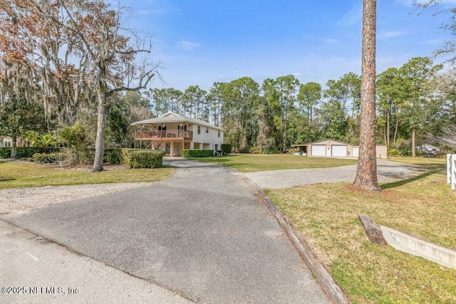 view of front of house featuring a detached garage and a front yard