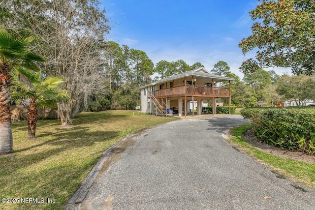 view of front facade featuring driveway, stairs, a front lawn, and a carport