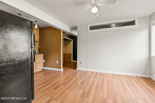 unfurnished room featuring light wood finished floors, ceiling fan, and baseboards