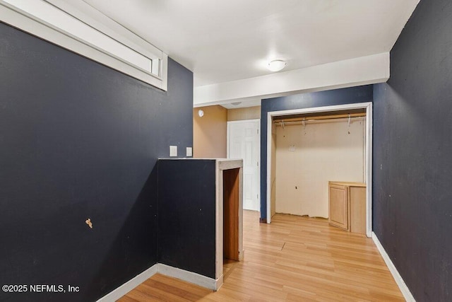 hall with light wood finished floors and baseboards