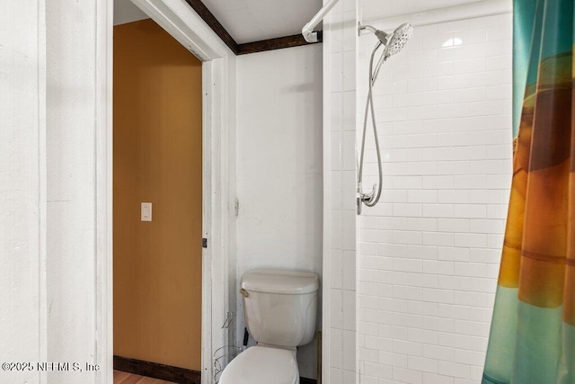 bathroom featuring toilet and a tile shower