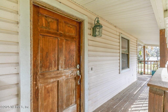 view of exterior entry featuring covered porch