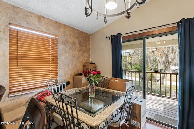 dining room with vaulted ceiling and a textured ceiling