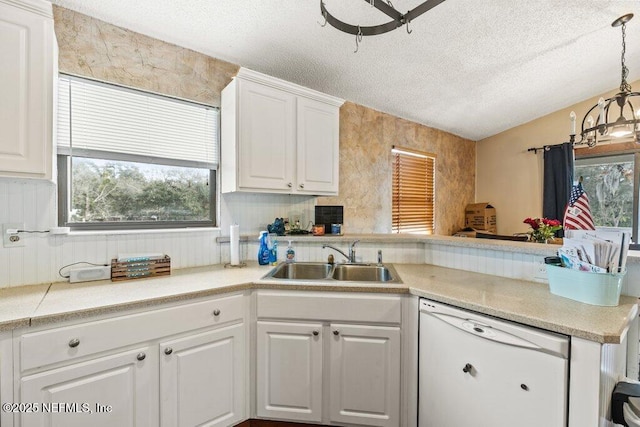 kitchen with a wealth of natural light, dishwasher, a peninsula, and a sink