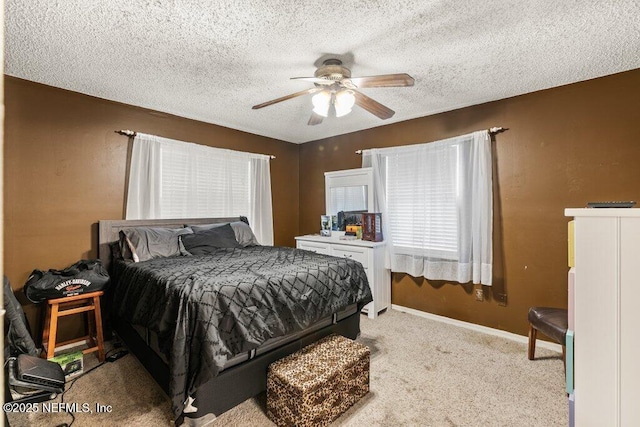 bedroom featuring a ceiling fan, light colored carpet, a textured ceiling, and baseboards