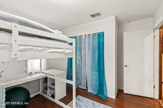 bedroom featuring a textured ceiling, wood finished floors, and visible vents