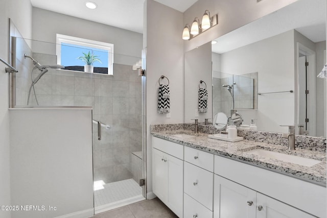 bathroom featuring double vanity, walk in shower, and a sink