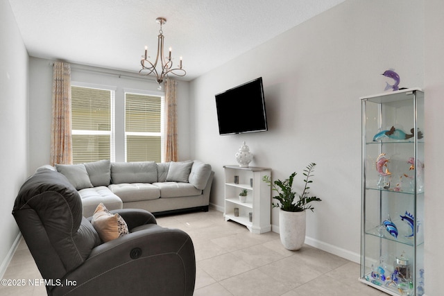 living area with a chandelier, light tile patterned floors, and baseboards