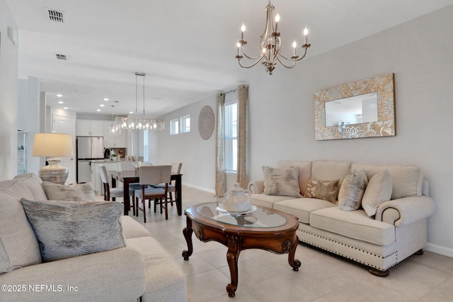 living area with baseboards, visible vents, and a chandelier