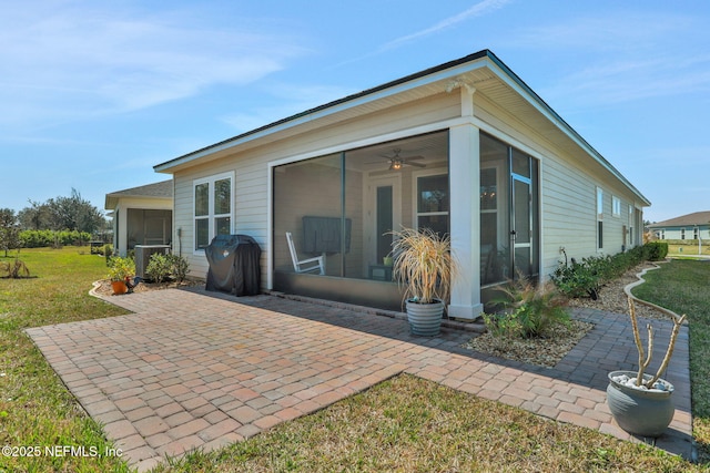 back of property featuring a sunroom, a yard, and central air condition unit