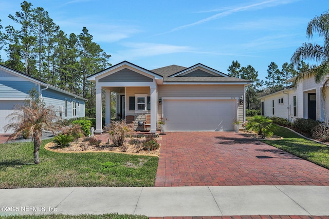 view of front of home with a garage, decorative driveway, and a front yard