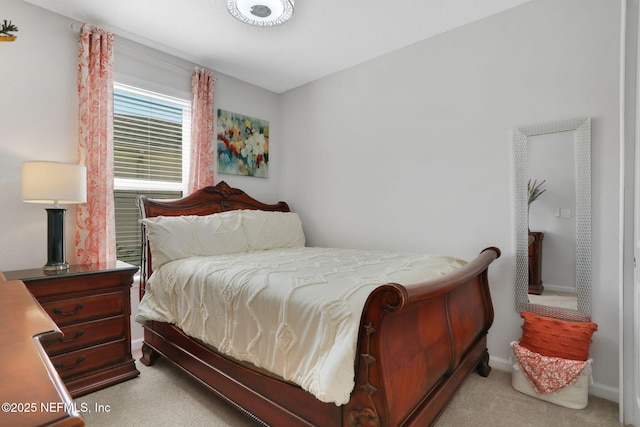 bedroom featuring light colored carpet and baseboards