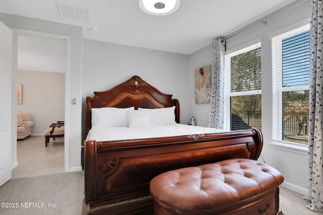 carpeted bedroom with tile patterned flooring, visible vents, baseboards, and multiple windows