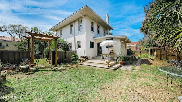 rear view of house featuring a fenced backyard, a chimney, a yard, a pergola, and stucco siding