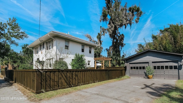 view of property exterior featuring an outbuilding, fence, a detached garage, and stucco siding