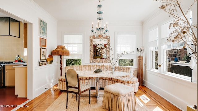 dining space with ornamental molding, wood finished floors, visible vents, and an inviting chandelier