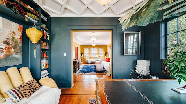 interior space featuring coffered ceiling, wood finished floors, and beam ceiling