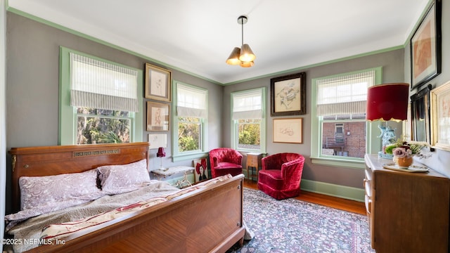 bedroom featuring baseboards and wood finished floors