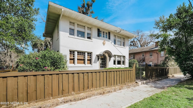 view of front of home with a fenced front yard and stucco siding