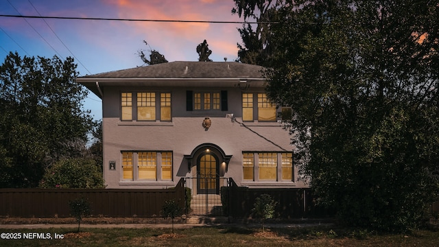 view of front facade featuring fence and stucco siding