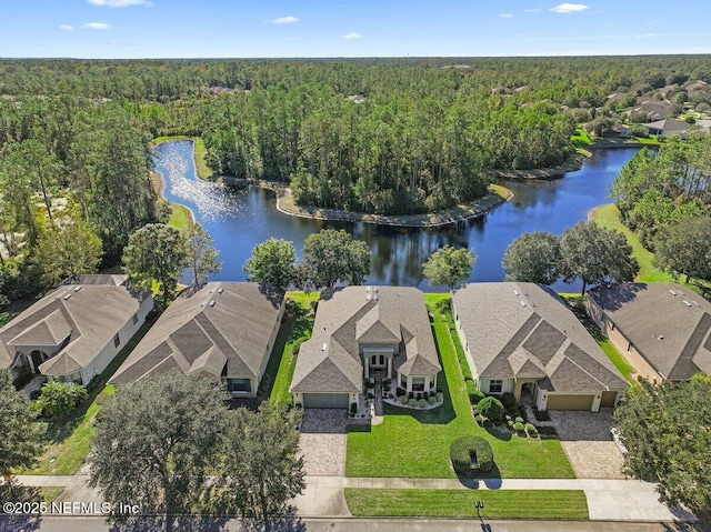 aerial view featuring a residential view, a wooded view, and a water view