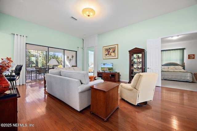 living room with hardwood / wood-style flooring and visible vents