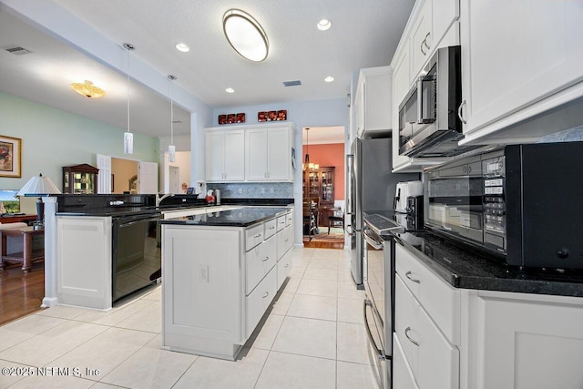 kitchen featuring light tile patterned floors, tasteful backsplash, a kitchen island, appliances with stainless steel finishes, and a peninsula