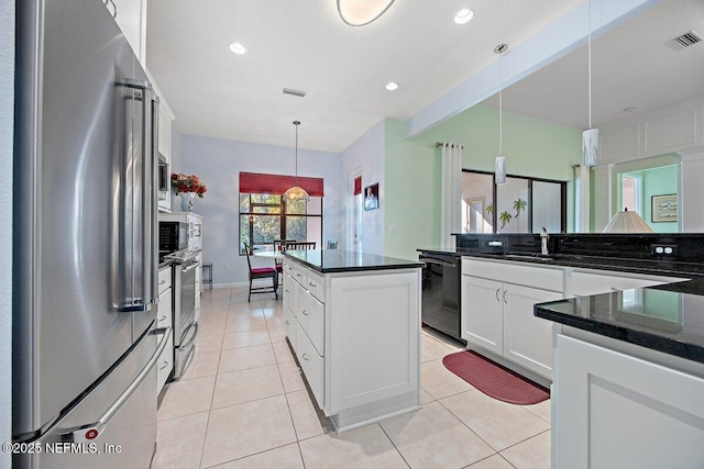 kitchen featuring visible vents, dishwasher, high end fridge, a center island, and a sink