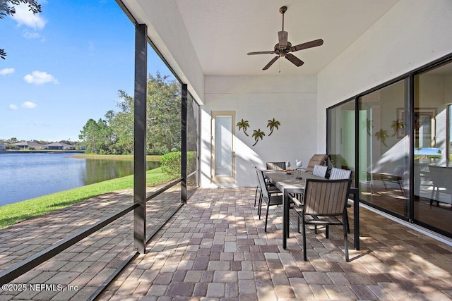 unfurnished sunroom with ceiling fan and a water view