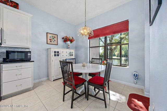 dining room featuring a chandelier, baseboards, and light tile patterned floors