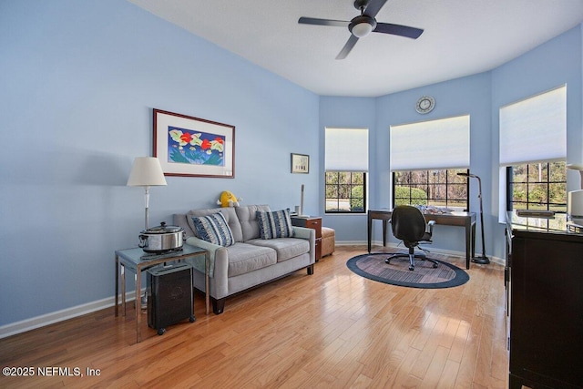 home office featuring light wood-type flooring, baseboards, and a ceiling fan