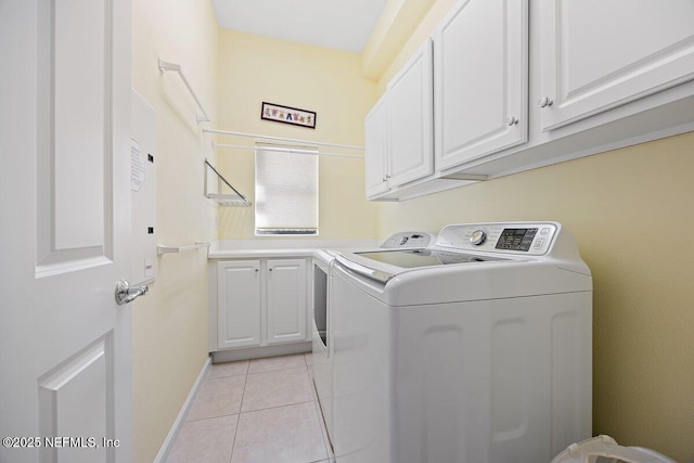 laundry room with cabinet space, light tile patterned floors, and washer and dryer