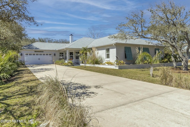 single story home featuring a chimney, stucco siding, an attached garage, a front yard, and driveway