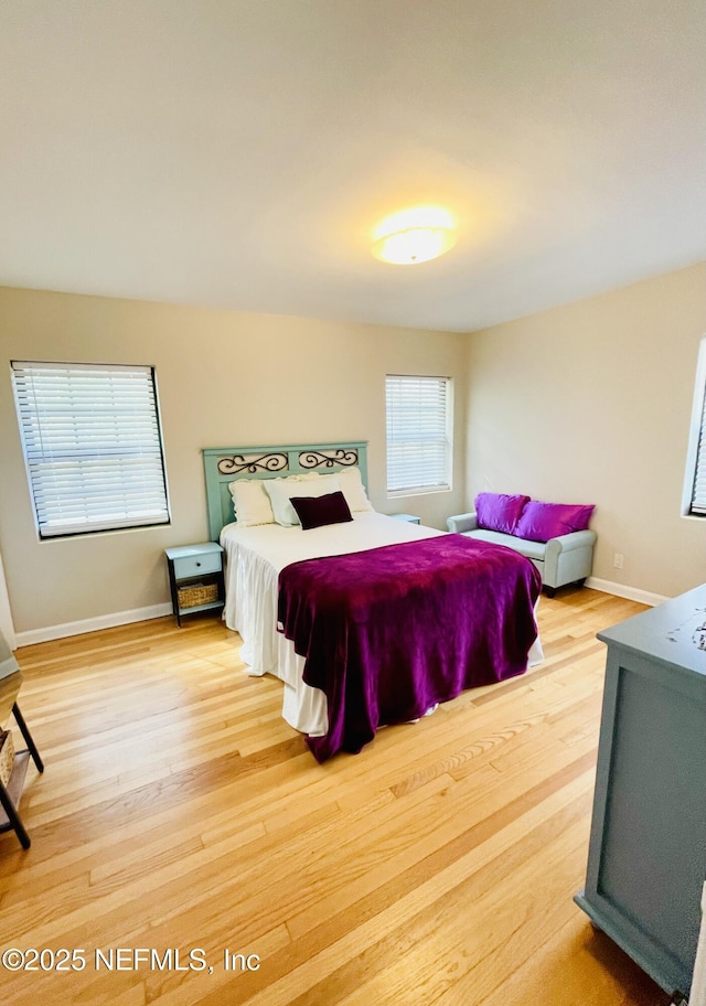 bedroom with wood finished floors and baseboards