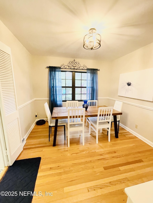 dining area featuring light wood-style flooring and baseboards