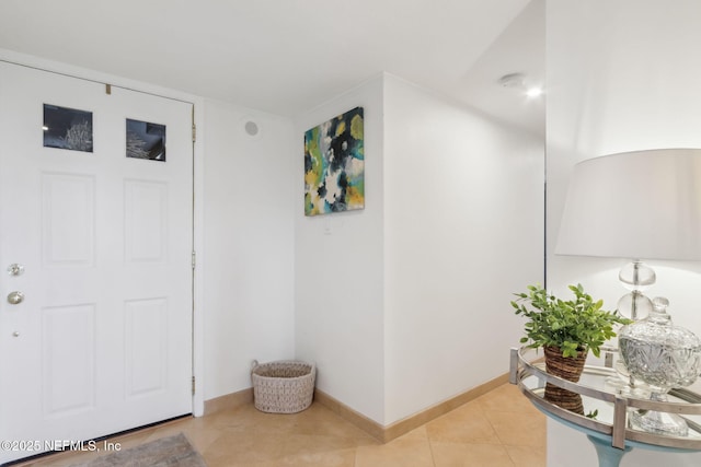 entryway with light tile patterned floors and baseboards