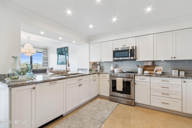 kitchen featuring tasteful backsplash, appliances with stainless steel finishes, a peninsula, stone counters, and a sink