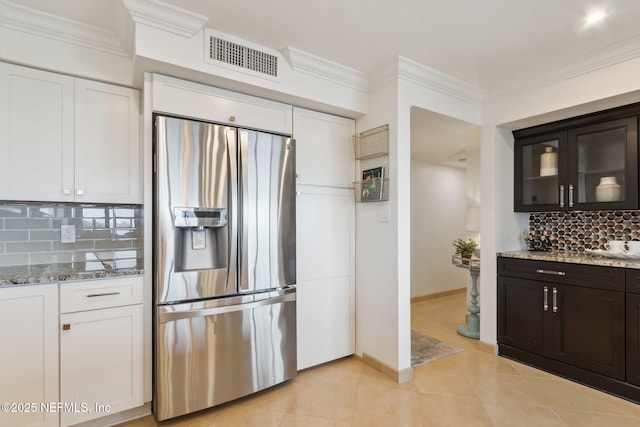 kitchen with white cabinets, ornamental molding, visible vents, and stainless steel fridge with ice dispenser