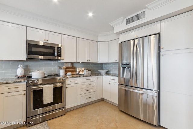 kitchen with light tile patterned flooring, stainless steel appliances, visible vents, decorative backsplash, and crown molding