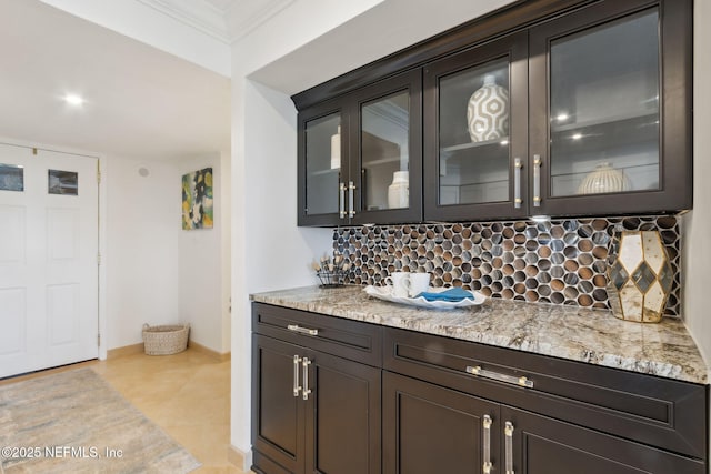 bar featuring baseboards, crown molding, and decorative backsplash