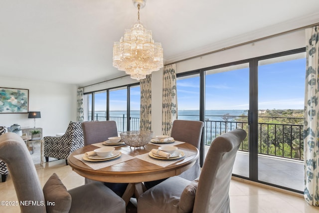 dining space featuring light tile patterned floors, a water view, ornamental molding, and an inviting chandelier