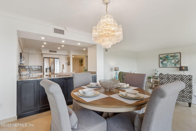 dining space featuring light tile patterned floors, a notable chandelier, visible vents, and crown molding