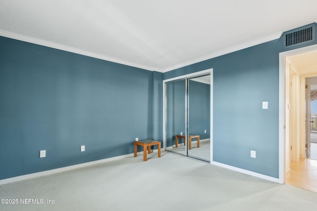 unfurnished bedroom featuring a closet, visible vents, crown molding, and baseboards