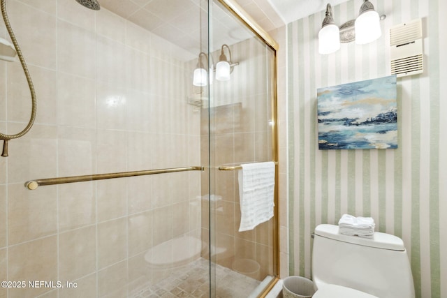 bathroom with toilet, wallpapered walls, and a shower stall